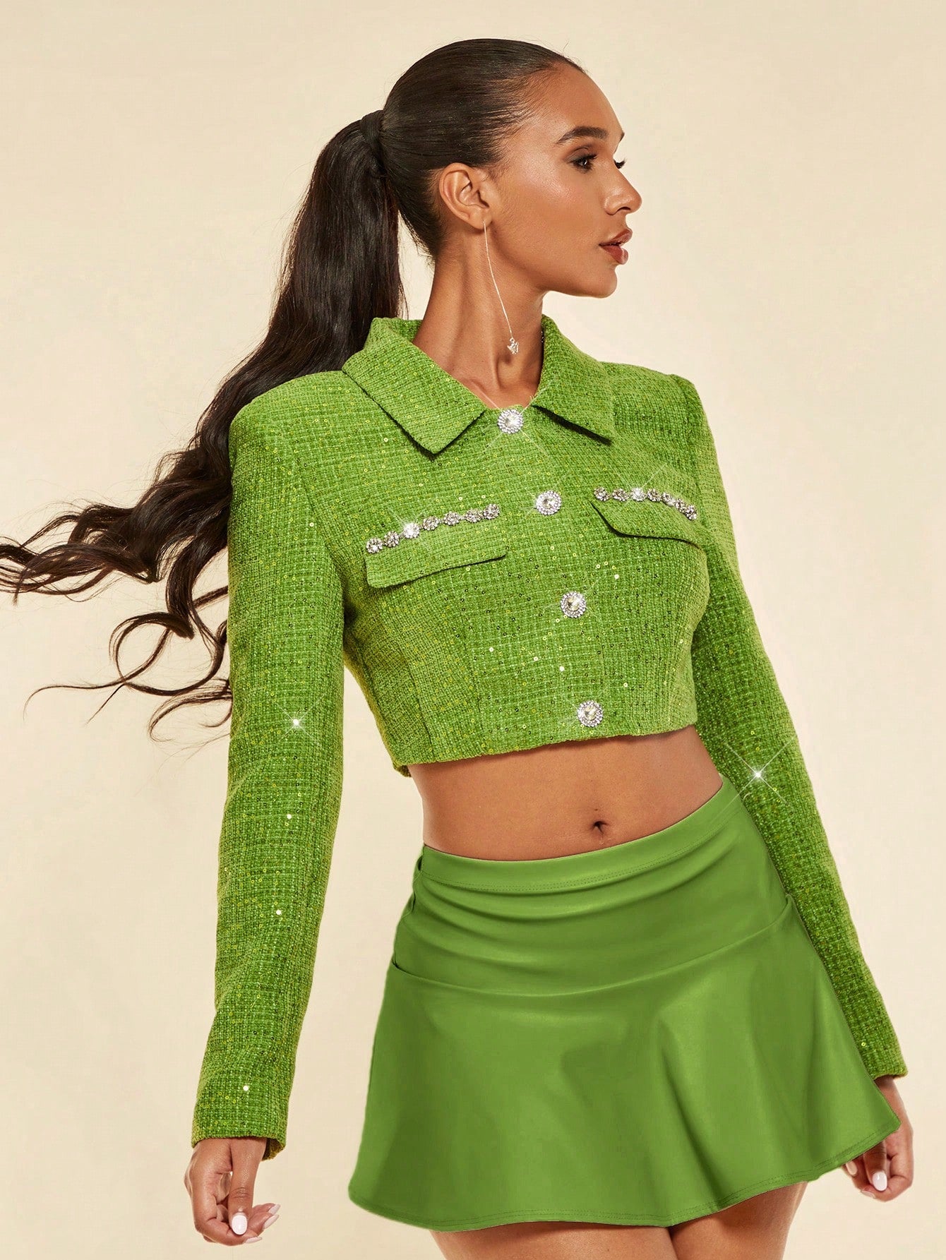 product picture of a model wearing aGreen glitter jacket with a green leather skirt
