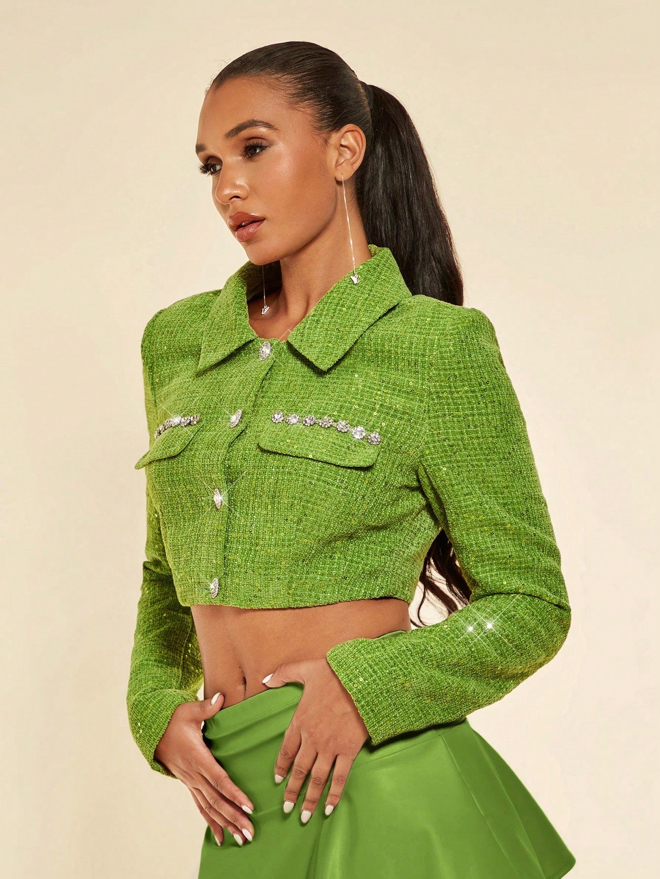 model posing for a professional photoshoot and a product picture, she wears a Green glitter jacket and silver jewelry