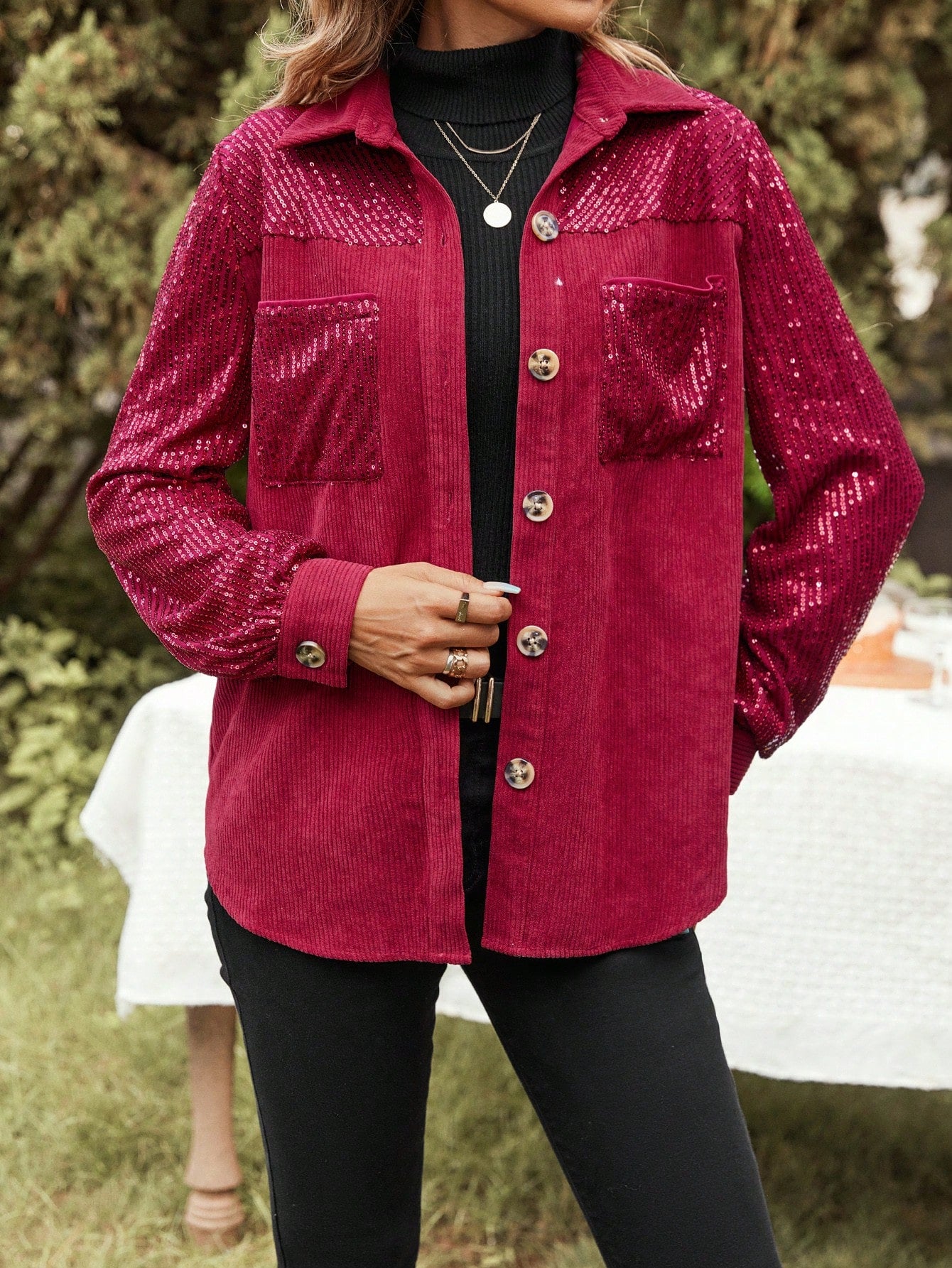 model posing for a professional product picture weargin a Red glitter jacket with black sweater and black pants