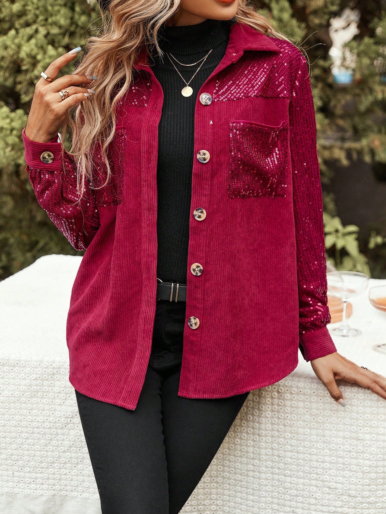 Red glitter jacket paired with a black sweater and black jeans