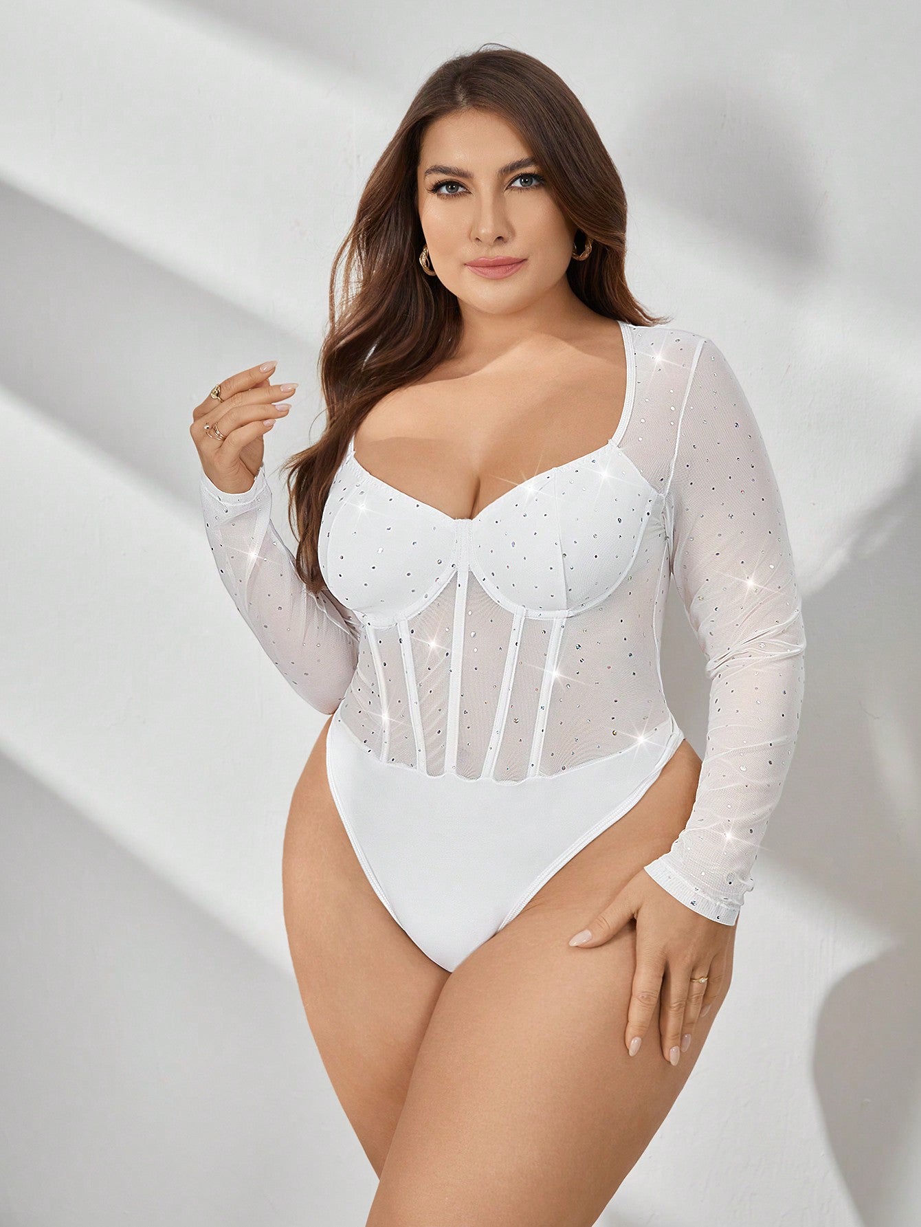 plus size model posing with a Plus size white sequin bodysuit for a professional photoshoot