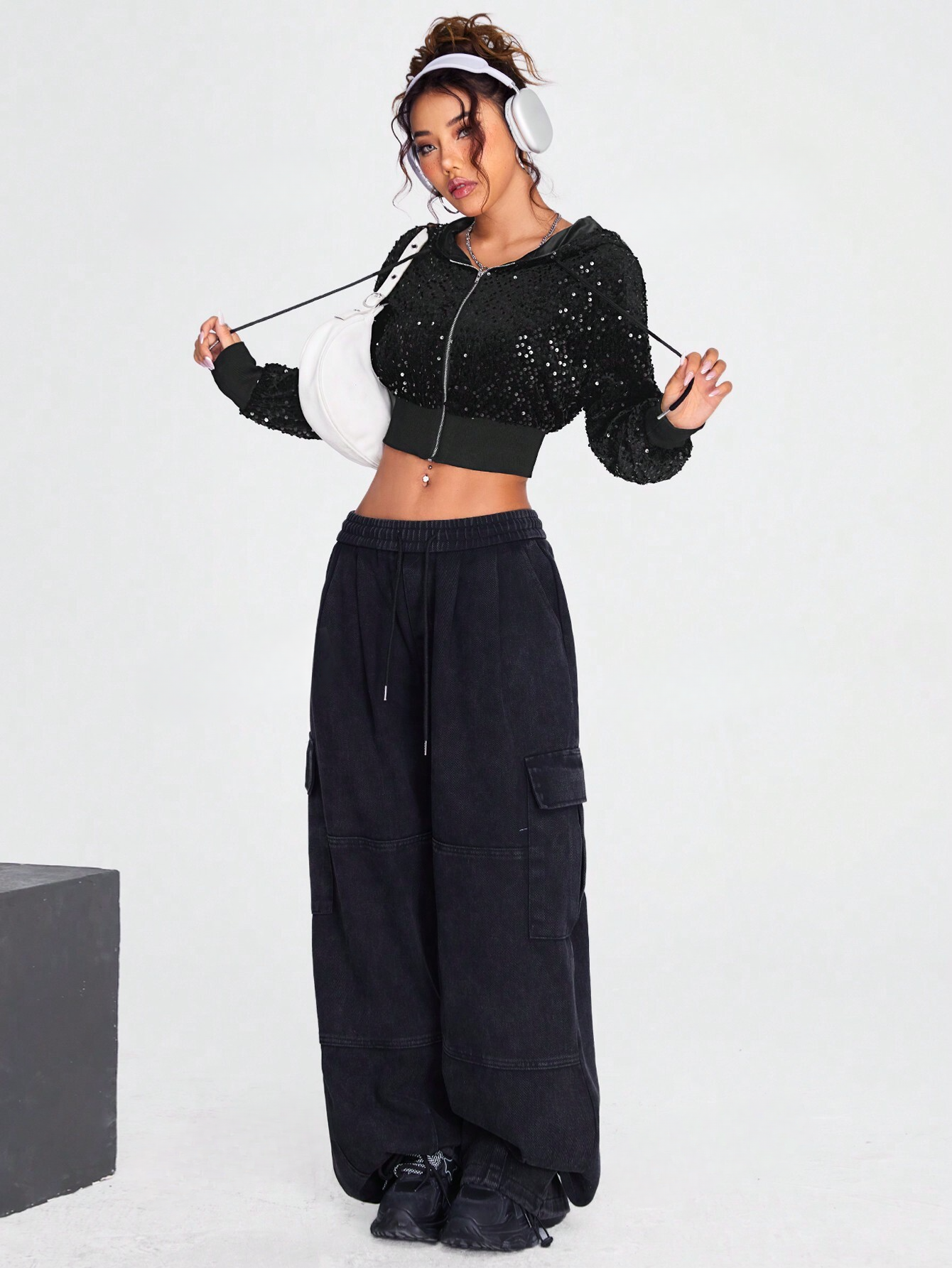 Black cropped sequin jacket worn by a model with a baggy jeans on a white background