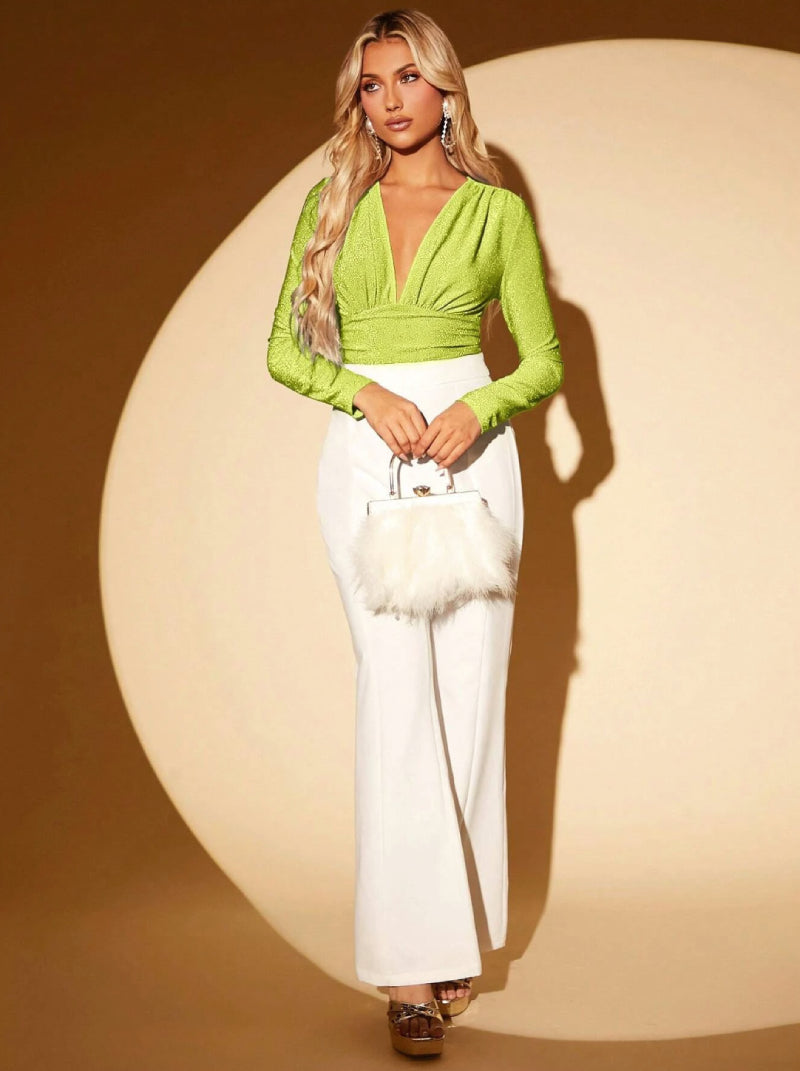 model posing with a Green glitter bodysuit, she holds a white bag with elegant fur and a beautiful loose white pant with some sandals
